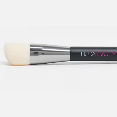 Makeup brush with Huda Beauty branding on a white background