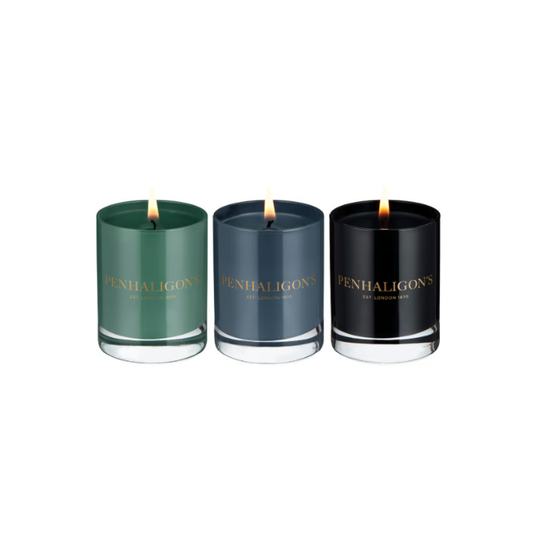 Three Penhaligon's candles in green, blue, and black on a white background